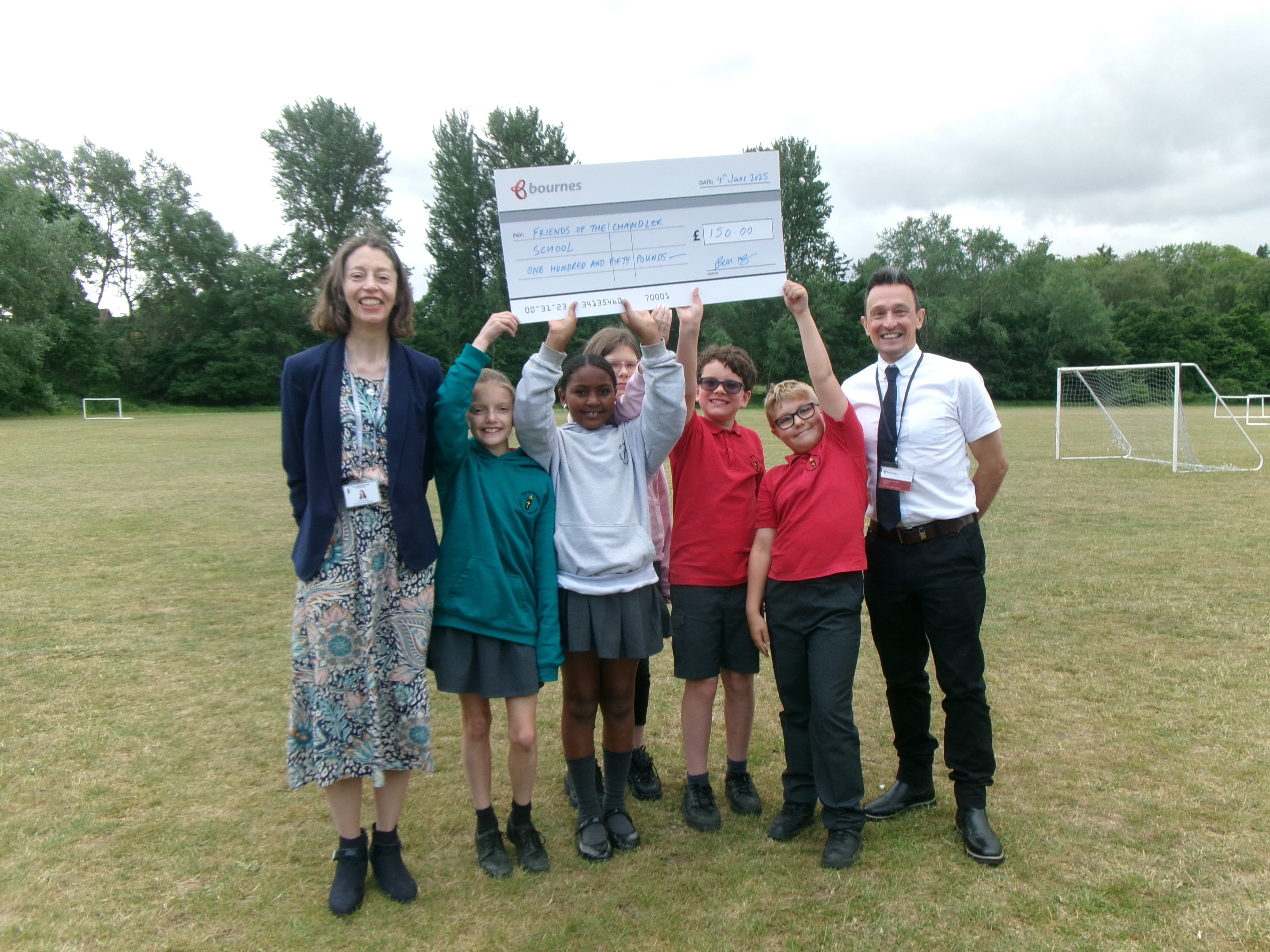 friends of chandler school are presented £150 byBournes Surrey Removals branch manager 